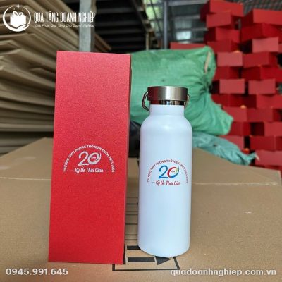 Thành phẩm bộ quà tặng gồm bình giữ nhiệt trắng in logo kỷ niệm 20 năm cùng hộp xi đỏ tại xưởng đóng gói
