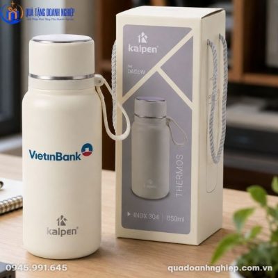 Hộp đựng của bình giữ nhiệt Kalpen với quai xách dù chắc chắn đặt cạnh sản phẩm trên bàn làm việc gỗ