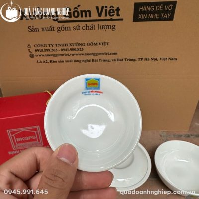 Cận cảnh chén chấm nhỏ men trắng cầm trên tay in logo Định Vị Bách Khoa sắc nét