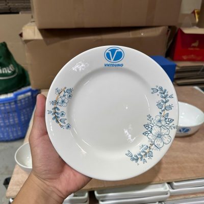Cận cảnh đĩa sứ trắng trong bộ 9 món in logo VietDung kết hợp họa tiết hoa dây xanh vẽ tay mềm mại