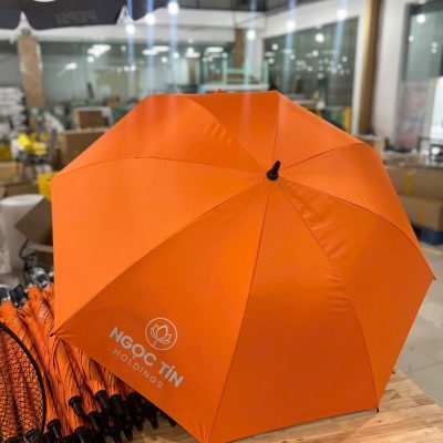 Mẫu ô dù màu cam in logo Ngoc Tin Holdings sắc nét tại xưởng sản xuất