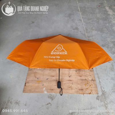 Ô dù cầm tay gấp gọn màu cam đặt trên tấm gỗ mộc trong quá trình kiểm thử độ bền