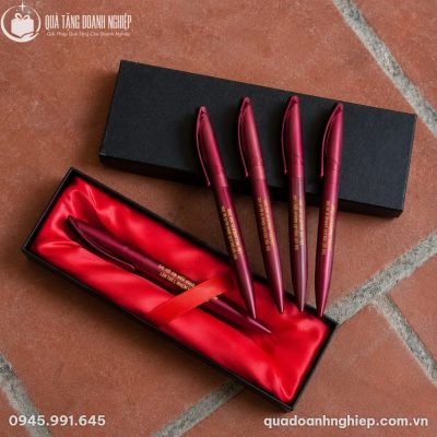 Bộ sản phẩm bút bi BK-01 xếp cùng hộp lót nhung đỏ sang trọng trên nền gạch nung truyền thống