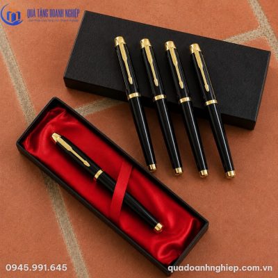 Bộ bốn cây bút ký kim loại BK-14 xếp cạnh hộp đựng lót lụa đỏ sang trọng trên nền gạch nung