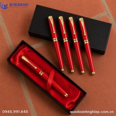 Hộp quà lót lụa đỏ chứa bút ký sang trọng bên cạnh các sản phẩm bút ký màu đỏ xếp gọn gàng