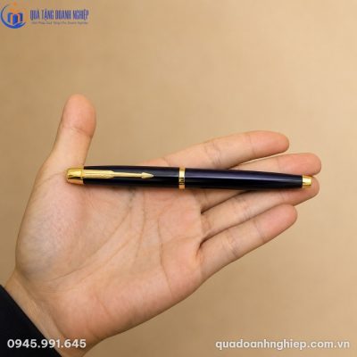 Cận cảnh thân bút ký màu xanh đen bóng loáng với các chi tiết mạ vàng tinh xảo khi đặt trên tay người sử dụng