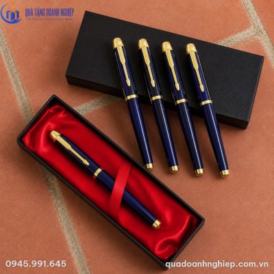 Bộ năm cây bút ký kim loại xanh navy mạ vàng xếp cạnh hộp xi lót nhung đỏ sang trọng