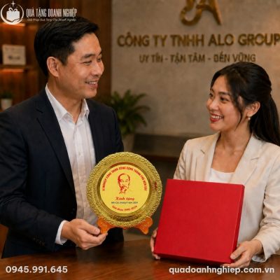 Đại diện doanh nghiệp trân trọng trao tặng đĩa biểu trưng lưu niệm đựng trong hộp quà màu đỏ sang trọng cho đối tác