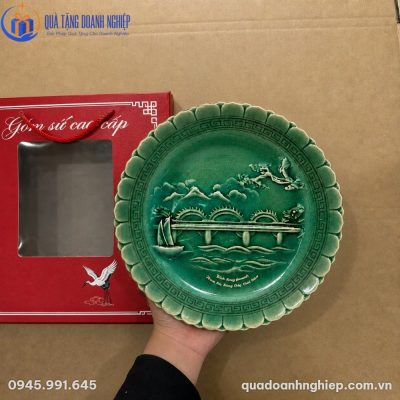 Chi tiết đĩa sứ men ngọc rạn mờ với hoa văn đắp nổi cầu rồng và thuyền buồm sắc nét khi cầm trên tay