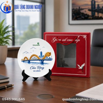 Đĩa biểu trưng sứ DBT-01 đặt trên bàn làm việc văn phòng hiện đại bên cạnh hộp xi đỏ sang trọng