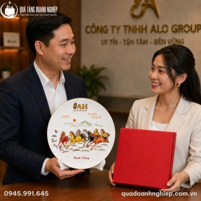 Đĩa sứ biểu trưng đặt kiêu hãnh trên giá đỡ gỗ đen bên cạnh bình hoa gốm sứ mộc mạc
