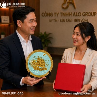 Đại diện doanh nghiệp trao tặng đĩa biểu trưng Thuận Buồm Xuôi Gió trong hộp xi đỏ lót lụa sang trọng