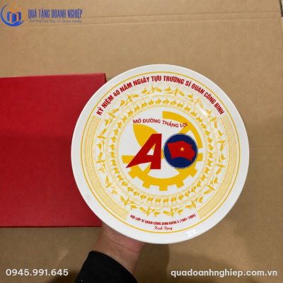 Cận cảnh bề mặt đĩa sứ trắng tráng men bóng bẩy được cầm trực tiếp trên tay thể hiện độ sắc nét của họa tiết Trống Đồng