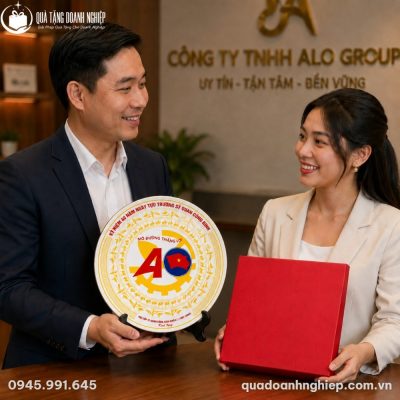 Đại diện doanh nghiệp trao tặng đĩa biểu trưng sứ Bát Tràng cùng hộp xi đỏ lót lụa cho đối tác tại văn phòng làm việc