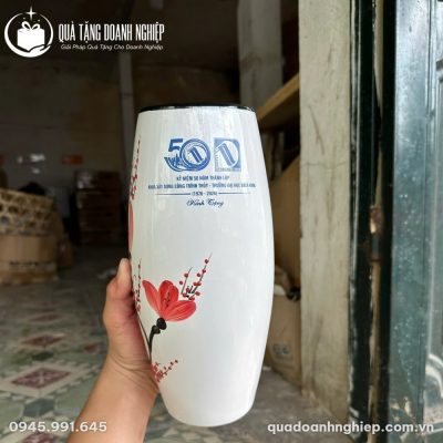 Lọ hoa sứ trắng vẽ tay hoa đào đỏ đặt cạnh hộp đựng lót lụa màu đỏ sang trọng