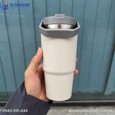 Cận cảnh lớp sơn tĩnh điện nhám màu kem của ly giữ nhiệt 710ml khi cầm trên tay di chuyển ngoài trời
