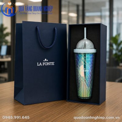 Hộp quà tặng cứng cáp cùng túi giấy đồng bộ đặt cạnh ly giữ nhiệt LGNQT-15 trên bàn gỗ công sở