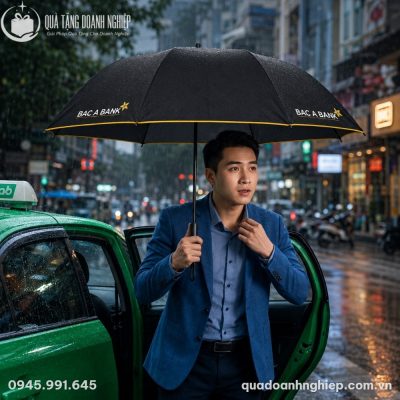 Thân ô đứng vững chãi trên bàn gỗ bên cạnh các sản phẩm ô gấp gọn đã đóng bao vải chỉnh chu