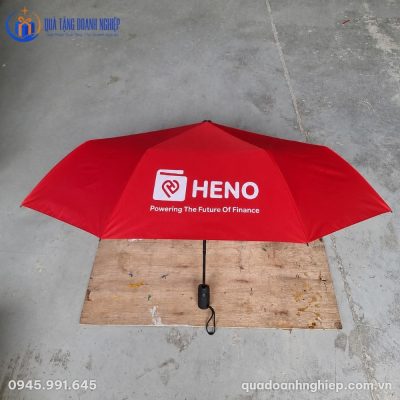 Cận cảnh chiếc ô gấp gọn màu đỏ in logo thương hiệu Heno đặt trên mặt sàn phẳng