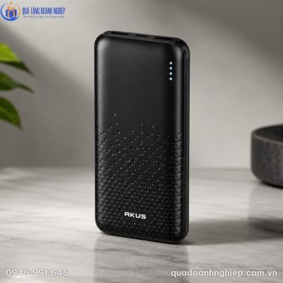 Cận cảnh pin sạc dự phòng Akus DP230 màu đen nhám đặt trên mặt bàn đá tự nhiên sang trọng