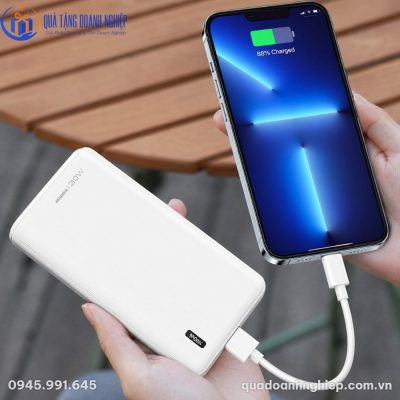 Người dùng cầm trên tay sạc dự phòng Remax RPP-287 màu trắng nhỏ gọn khi đang sạc điện thoại