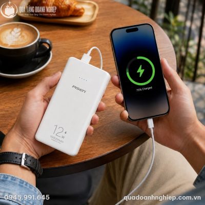 Người dùng cầm trên tay sạc dự phòng Pisen kết nối sạc tiện lợi trong không gian quán cà phê