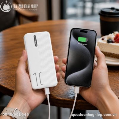 Người dùng cầm sạc dự phòng Remax RPP 297 kết nối sạc tiện lợi cho smartphone trong không gian quán cà phê