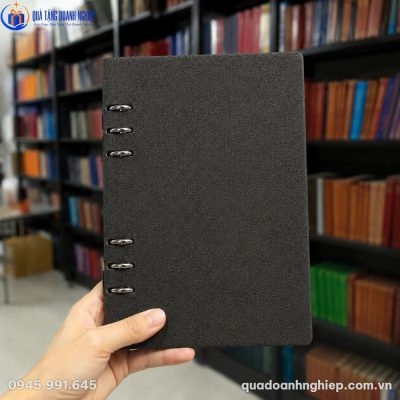 Cận cảnh bề mặt bìa da PU vân xước sần màu đen xám chì của sổ còng A5 trên tay người dùng