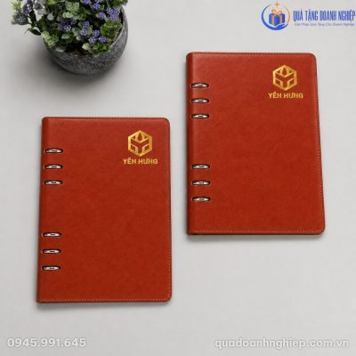 Nhân viên văn phòng cầm trên tay cuốn sổ da còng SD-16 trong không gian thư viện ấm cúng