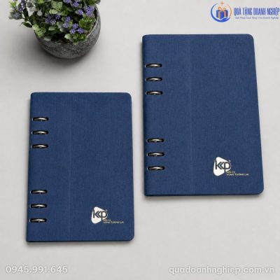 Hai kích thước sổ tay bìa da PU vân vải lanh màu xanh dương đặt cạnh chậu cây cảnh nhỏ