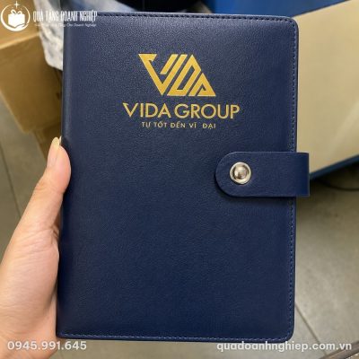 Cận cảnh cuốn sổ da SD-02 màu xanh navy cầm trên tay với logo Vida Group ép kim vàng sắc nét