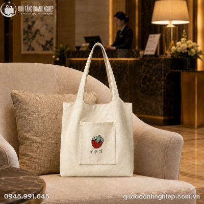 Túi canvas TVQT-08 đặt tựa vào gối tựa trên ghế sofa đơn tại sảnh chờ văn phòng hiện đại