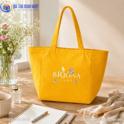 Túi canvas màu vàng tươi tắn đặt trong không gian làm việc ngập tràn ánh sáng tự nhiên