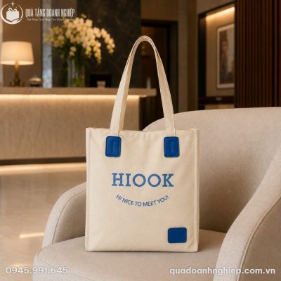 Túi tote canvas CVQT-04 đặt trên ghế sofa trong không gian sảnh chờ khách sạn sang trọng