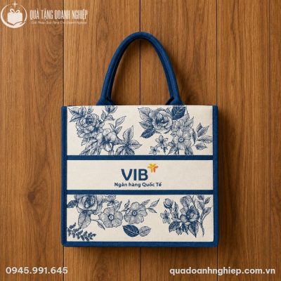 Cận cảnh túi vải canvas đặt trên nền gỗ tự nhiên thể hiện rõ chất liệu dệt thô mộc và đường may bo viền chắc chắn