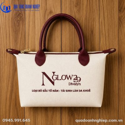 Túi canvas TVQT-18 chụp trực diện trên nền gỗ tự nhiên, làm nổi bật đường vân vải canvas dày dặn và quai da màu đỏ burgundy