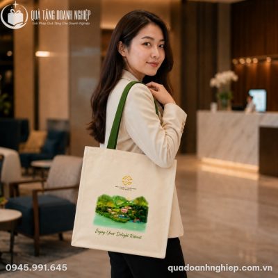 Nữ khách hàng mặc blazer công sở thanh lịch đeo thử chiếc túi vải canvas phong cảnh tại sảnh chờ của khách sạn