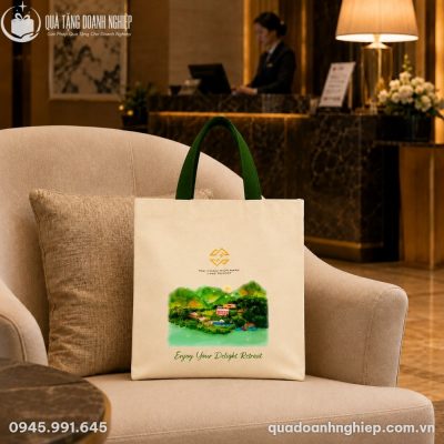 Túi vải bố in logo được sắp đặt gọn gàng trên ghế bành đơn tại không gian tiếp đón sang trọng