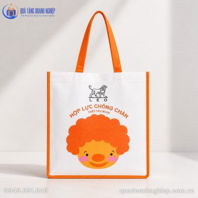Mặt trước của túi vải không dệt KDQT-03 với chi tiết in sắc nét trên nền vải trắng viền cam