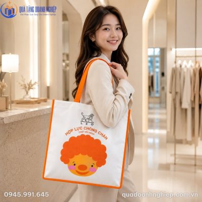 Người mẫu công sở đeo túi vải không dệt phối cam năng động trong không gian mua sắm hiện đại